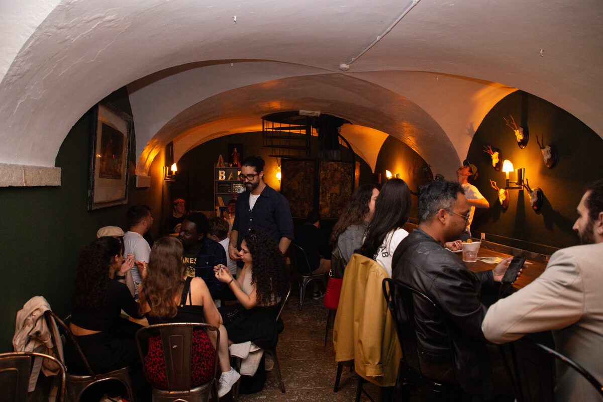 Guests talking over drinks in the vaulted back room